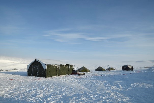 Quelques camps militaires déployés sont érigés au milieu d’un paysage enneigé de l’Arctique.