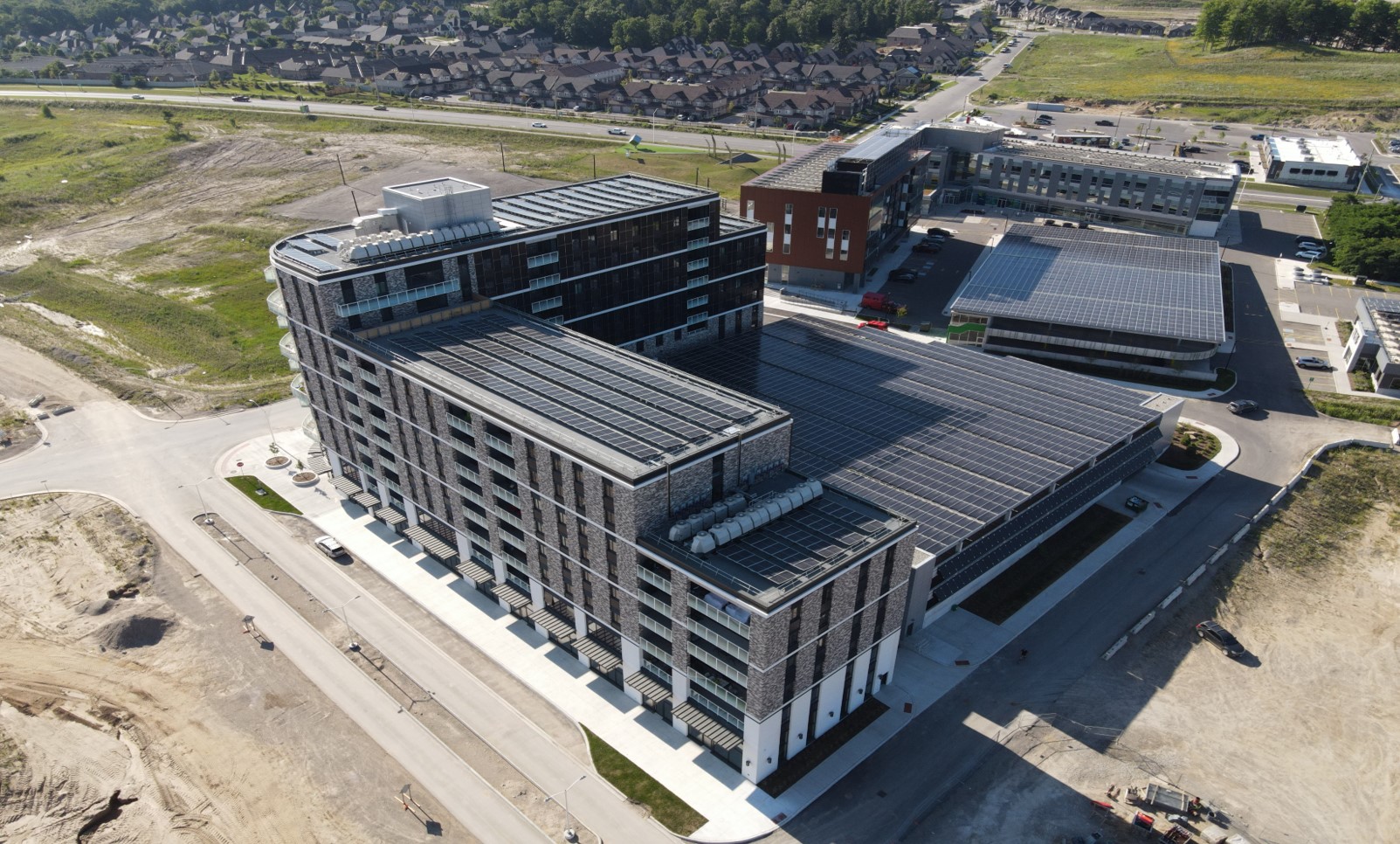 Photographie aérienne des édifices Legacy Square Plaza et Helio Commercial Retail Services, sur le toit desquels sont installés des panneaux solaires photovoltaïques.