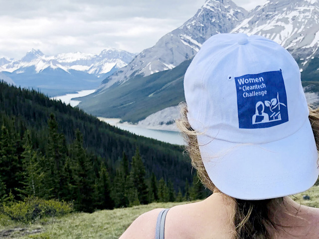 Sur l'épaule d'Amanda regardant une scène des montagnes Rocheuses. Elle porte une casquette blanche avec le texte : Women Cleantech Challenge