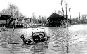 photographie d’archive d’une vieille voiture submergée par l’eau dans une rue inondée de London, en Ontario